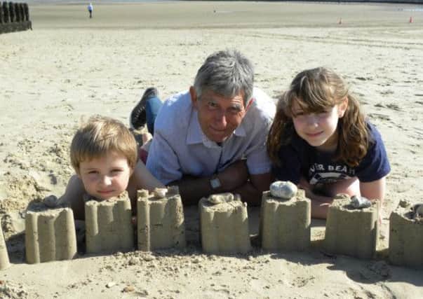 Ron Green and his grandchildren Ruben, seven, and Meryl, 10, enjoying the sand