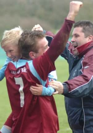 Jake Daniels and Chris Cumming-Bart celebrate with a young supporter after Little Common clinched promotion. Picture by Simon Newstead
