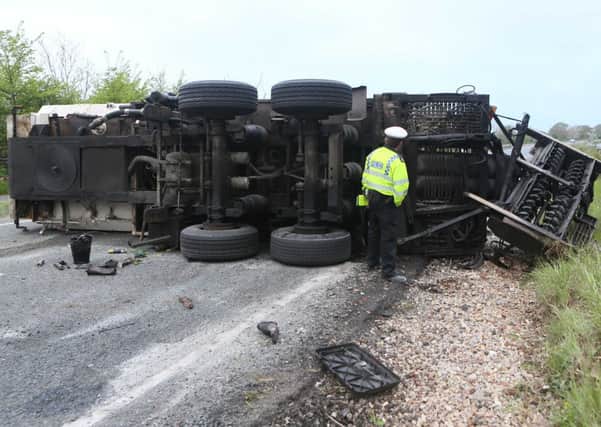 Officer looks on at the lorry which lost control and flipped on the A27 westbound, near Arundel. PICTURE: Eddie Mitchell