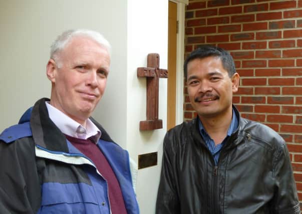 Chomno In meets Doug Fletcher (manager of The Centre, Horsham) at Brighton Road Baptist Church, pictured alongside a wooden cross made by a student from the Safe Haven School in Poipet, part of a programme to rehabilitate trafficked children - submitted picture