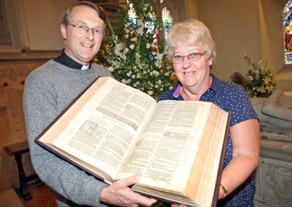 Canon Guy Bridgewater pictured in 2011 at the 400th anniversary of the King James' Bible, St. Mary's Parish Church, Horsham Flower festival. With him is with Val Burgess with a first edition King James' Bible c. 1611-13 -photo by steve cobb
