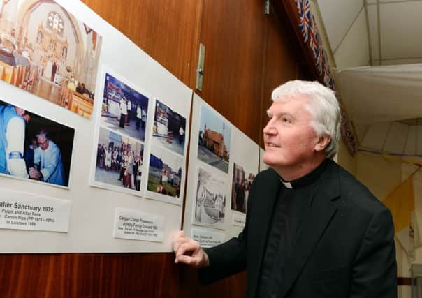 Father Dominic OHara looks at St Catherines history at a display in the church to mark its 150th year    L22080H13