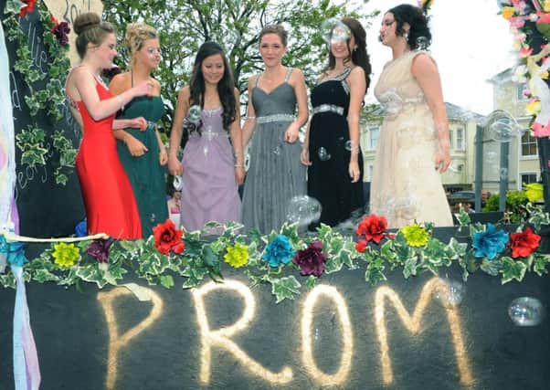 Girls stand proud: bubbles are blown above a prom platform