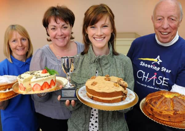 JPCT 010613 S13230141x Horsham Swan Walk, Cake baking competition. Judges with finalist entries. Cat Dresser holds the winning cake with the trophy  -photo by Steve Cobb