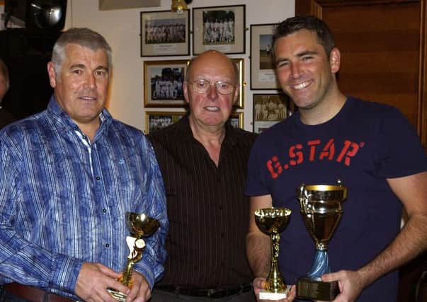 Sports club chairman Ray Kidd presents a trophy to Grant Skinner and Paul Thompson