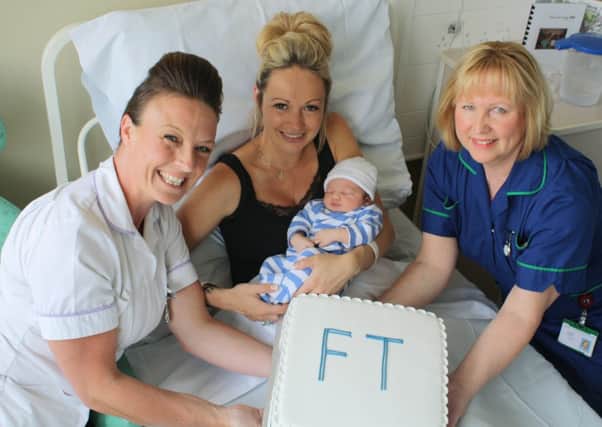Baby Harry Peter Lee Balchin, with mum Lindsey McClure, getting a celebratory cake from student midwife Debbie Furniss (left) and midwife Jacquie Phelan (right) at St Richard's Hospital