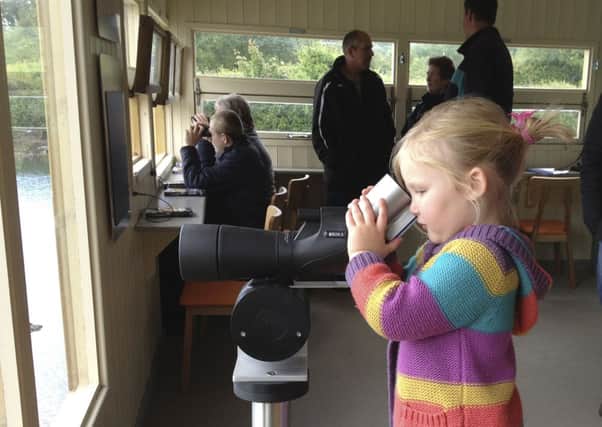 Young Sophie Rooney watches wildlife through a viewing scope at Arundel Wetland Centre