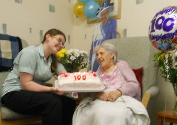Ethel Keast, 100, celebrates her birthday with a staff member