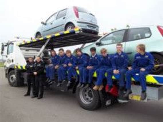 Engineering students at Hastings College with two donated cars
