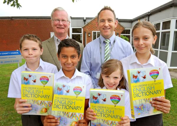 JPCT 280613 Rotary club presents dictionaries to Heron Way School. Gordon McConnell ( Horsham Rotary club ) left with headteacher James Crump and pupils L to R Cameron 11, Amish 10, Lilly-May and Kasey 10 Photo by Derek Martin