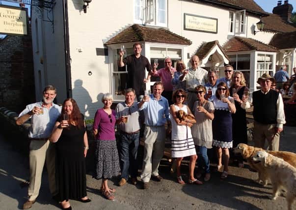 MP Nick Herbert (front row, centre) raises a glass to toast the future of The George at Burpham