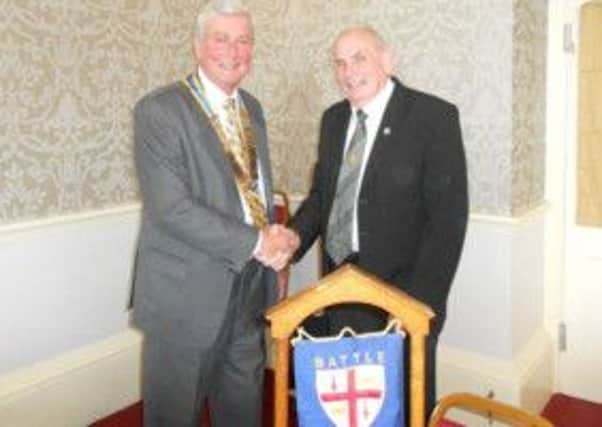 Immediate Past President Dave Ballard handing over the Rotary Club of Battle's Chain of Office to new President Mike Bett at the Club's meeting last Tuesday.
