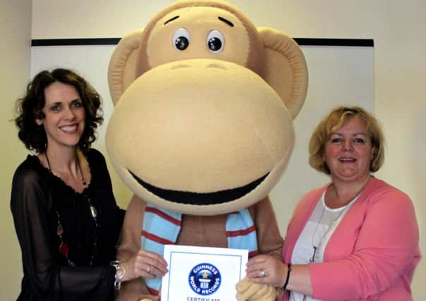 Gail Bunn, marketing and communications manager at SignHealth, Olli the monkey and Linda Petrons, events and corporate fundraiser at SignHealth, with the certificate from Guinness World Records