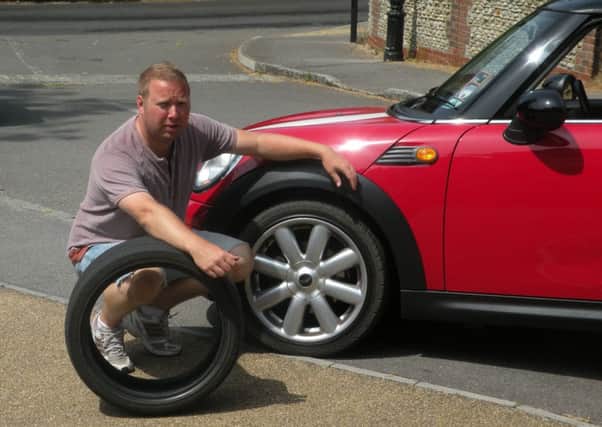 Mark Butler with the wheel of his car that was damaged last year by a pothole