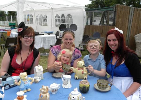 Mad Hatter Jessie May Hodder (left) with mice Rachel Brain and Aston Telford, eight, serving tea, Jessica Catterick, two and Nicky Thompson, as Alice
