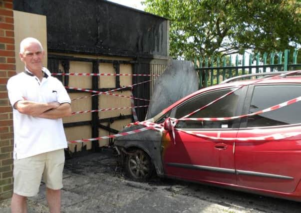 Devastated Mark Loten, 50, stands beside whats left of his torched car