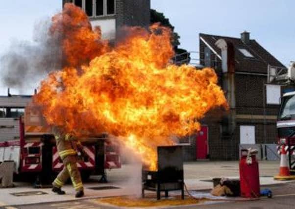 A firefighter tackles a blaze at a fire station open day