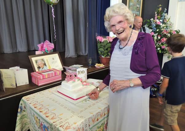 Kathleen Shaw cuts her cake at her 100th birthday party