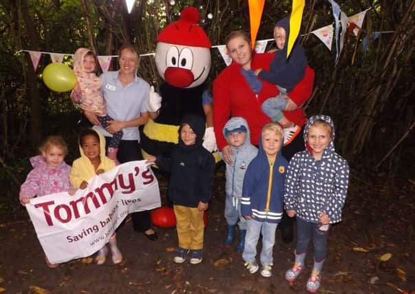 Charlotte, Amy and Ethan holding a Tommy's charity banner, above is Isla holding a Peppa pig balloon with Charlotte the Assistant Manager. Bottom right is Ben, Thomas and Magdalena and above Gemma who helped to organise the event is holding a little boy called Louis.