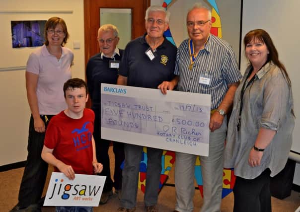David Gill, president of Cranleigh Rotary Club (2nd from right), is joined by Rotarians Brian Arendell and John Menlove to present a cheque to representatives of Jigsaw Trust.