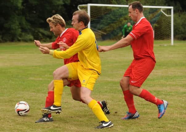 Bosham's Andy Probee, in red, tries to keep Lavant from possession  Picture by Louise Adams C131277-1