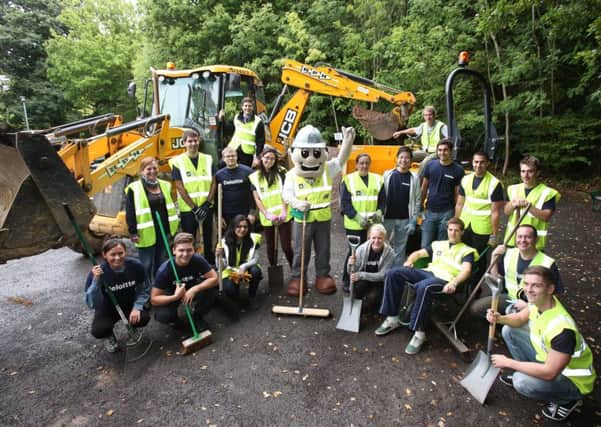 Barratt Homes Site Manager Barry Kerr, top left on JCB Mascot Barry Barratt, and David Spreadbury-Troy, top left on dump-truck, with volunteers from DeLoitte and Buxted Constuction.