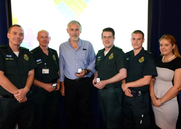 Adam MacDiarmaid-Gordon from Shoreham and the SECAmb team who saved him receive their pin badges from Andy Newton, director of clinical operations, far left