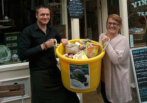 Jane Hart-Coombes and tea-room assistant David Millais with their bucketful of donations