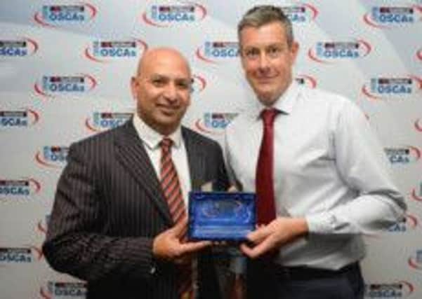 Azam Riyard receives his award from Ashley Giles