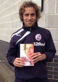 Crawley Town player Sergio Torres with his new book