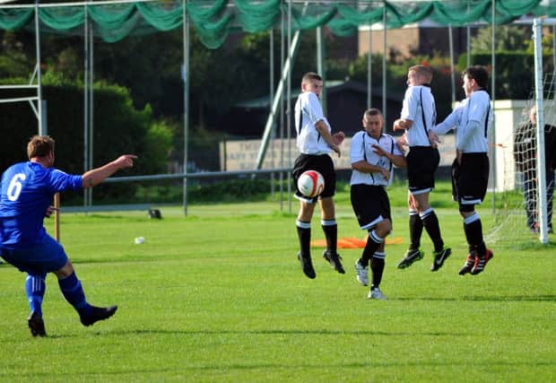Bexhill United's defensive wall stands firm during the 5-0 win at home to Midhurst & Easebourne on Saturday. Picture by Steve Hunnisett (eh42009d)