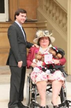 Mandy Paine MBE with her son Daniel outside Buckingham Palace on Thursday.