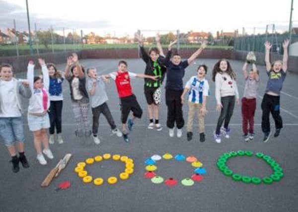 Youth club members at the Fairfield community centre in Burgess Hill, Sussex spell out 1,000 which is the amount donated in pounds by McCarthy and Stone who ran a campaign to find a worthy local cause to amrk their one thousandth development ***Pic by David McHugh 07768 721637***