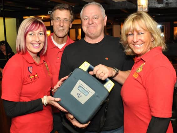 Henfield White Hart landlord Gyles Culver receives a heart defibrillator for the pub from HART responders, Sandra Parsons, Martin Tooth and Claire Greenfield. Pic by Mike Beardall, Oakfield Media