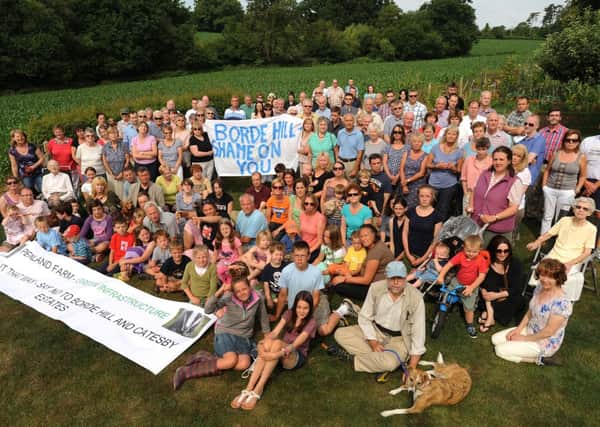 Residents near Penland Farm protest about the plan to build on Penland Farm land, pictured here in the field behind the group