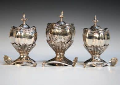 A set of three George II silver graduated tea caddies or condiment vases and covers by Nicholas Sprimont, London 1743.