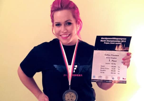 Precious Collins with her certificate and medal for winning a powerlifting title