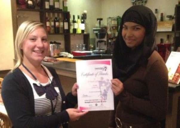 Jodie Dunk presenting a certificate of thanks from Meningitis UK to Afsana Tarafder, from a Touch of Spice