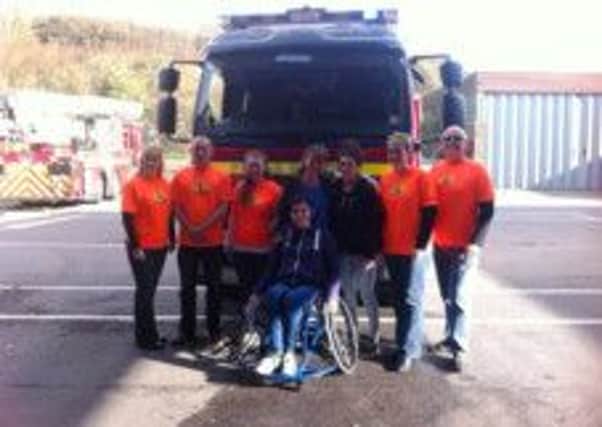 Nicole Martin with her new wheelchair with members of Charity for Kids at Bohemia Road Fire Station in Hastings