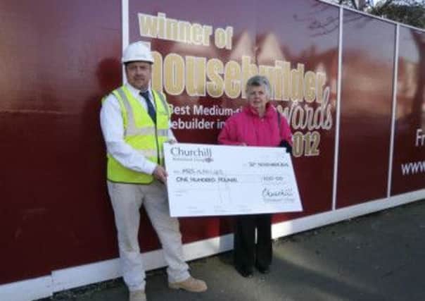 Ann Miller receives a cheque for £100 for winning a naming competition