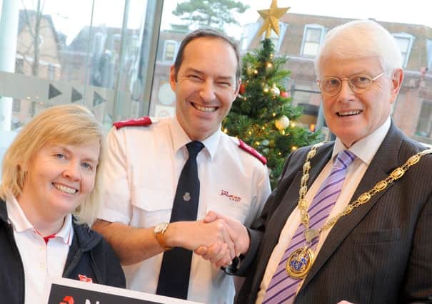 JPCT 161213 Major Ann Stewart and Major Iain Stewart receive a cheque from Cllr Philip Circus for the The Salvation Army. Photo by Derek Martin