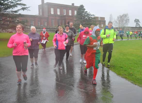 Runners battle their way through the rain in the Christmas Pudding Dash at Ashburnham Place on Saturday. Picture by Steve Hunnisett (eh52013f)