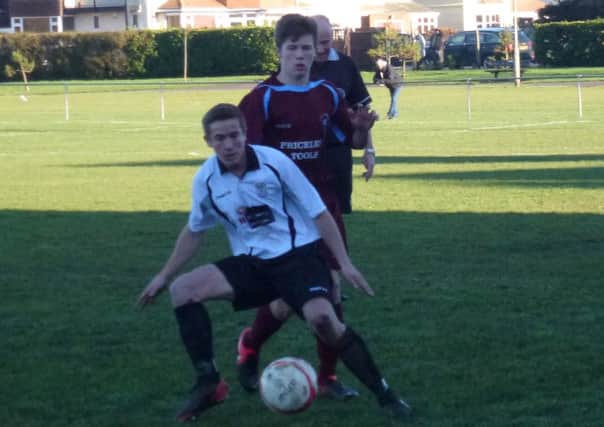 Bexhill United midfielder Dean Stevens shields the ball from Little Common youngster Sam Cruttwell. Picture by Simon Newstead