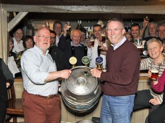 Quizmaster Nick Cowley (left) presents winning team Downside Up with their barrel of beer
