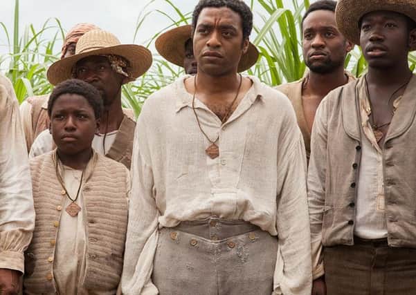 Chiwetel Ejiofor (centre as Solomon Northup in 12 Years a Slave.