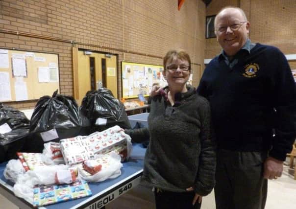 Lion John Williams, Horsham Lions Services Chair - on the right and Mandy Jones, The Project Manager of "Ark"  on the left) receiving 55 of the 78 Food Parcels for Horsham Needy Families and 22 sets of presents for their children