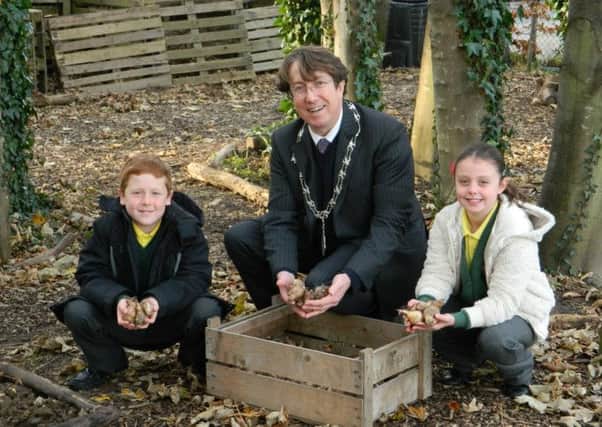 Rustington parish councillor Andy Cooper, pictured centre, will be attending a village surgery this month. Here Andy is pictured with Summerlea Primary School pupils George Dagg and Darcey Tidy planting bulbs at the village school.