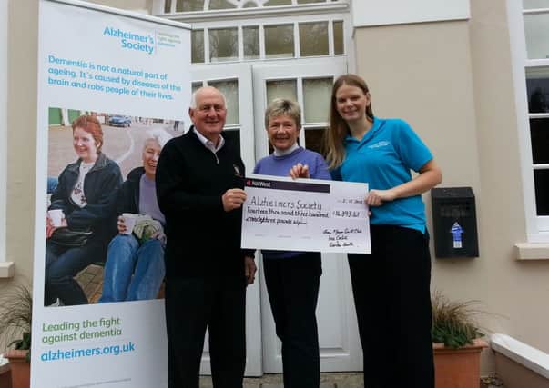 Captains Gordon Smith and Ina Cahil handing over a cheque for Â£14,393.41 to the Alzheimers Society