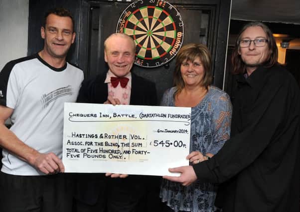 Cheque presentation to Hastings & Rother Voluntary Association For The Blind from The Chequers Pub, Battle, after their 24 hour dartathon. L-R Garry Simmonds, Zuqi Zvuxqy, Fieona Farrier-Twist (Voluntary Assoc for the Blind) and Wayne Martin.  Fieona is correct spelling, and Zuqi Zvuxqy is also correct.
