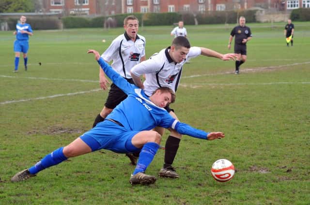 Bexhill United striker Jacob Shelton seeks to skip away from a Storrington opponent on Saturday. Picture by Steve Hunnisett (fh03014a)